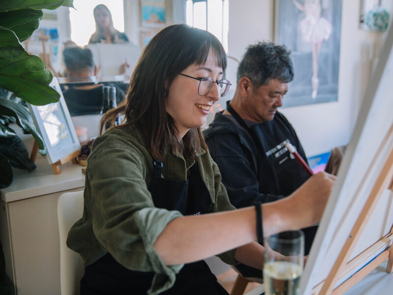 Couple painting at a paint and sip class. 